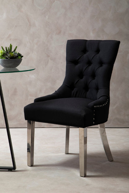 Black upholstered chair with silver legs in a room setting