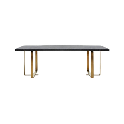 Dining table with a dark surface and gold metal legs on a white background