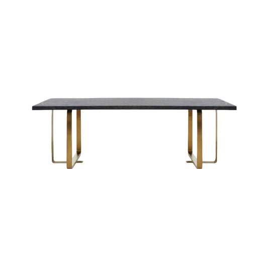 Dining table with a dark surface and gold metal legs on a white background