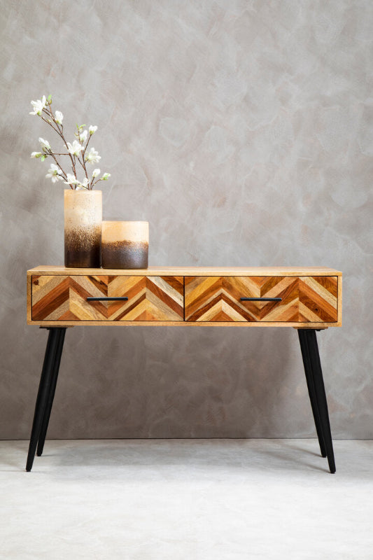 Wooden console table with geometric design against a gray wall