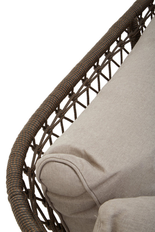 Close-up of a wicker chair with a beige cushion on a white background