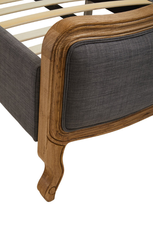 Bed with wooden frame and gray upholstered headboard on a white background