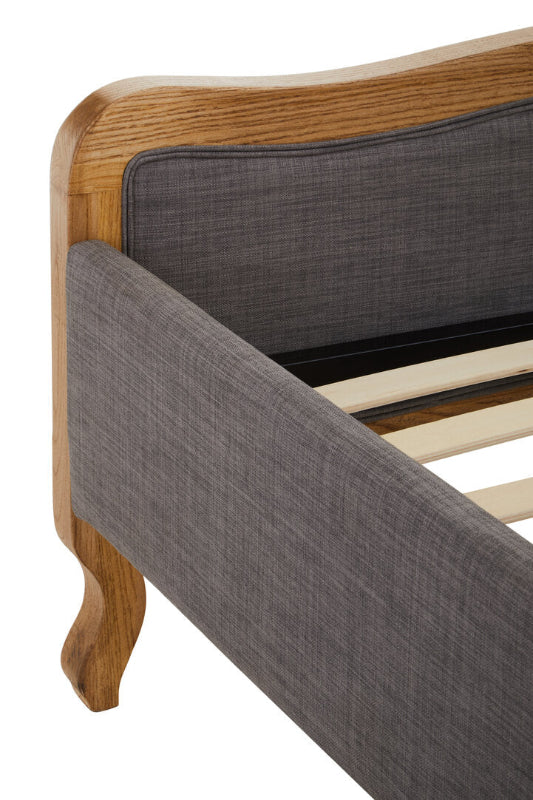 Gray upholstered bed with wooden frame and slats on a white background