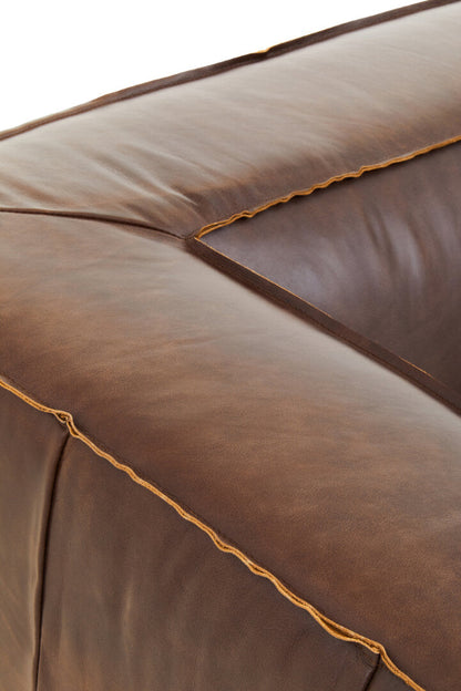 Close-up of a brown leather sofa with visible stitching.