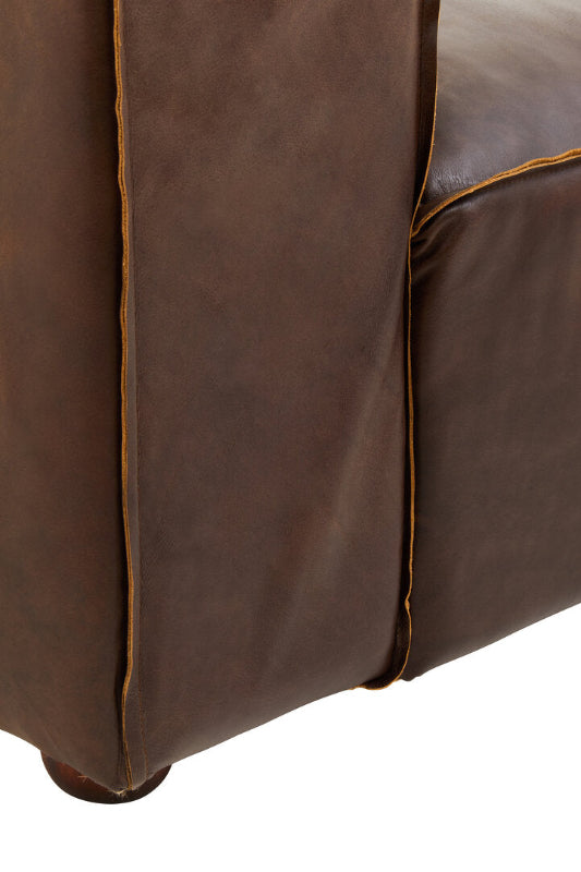 Close-up of a brown leather sofa corner on a white background