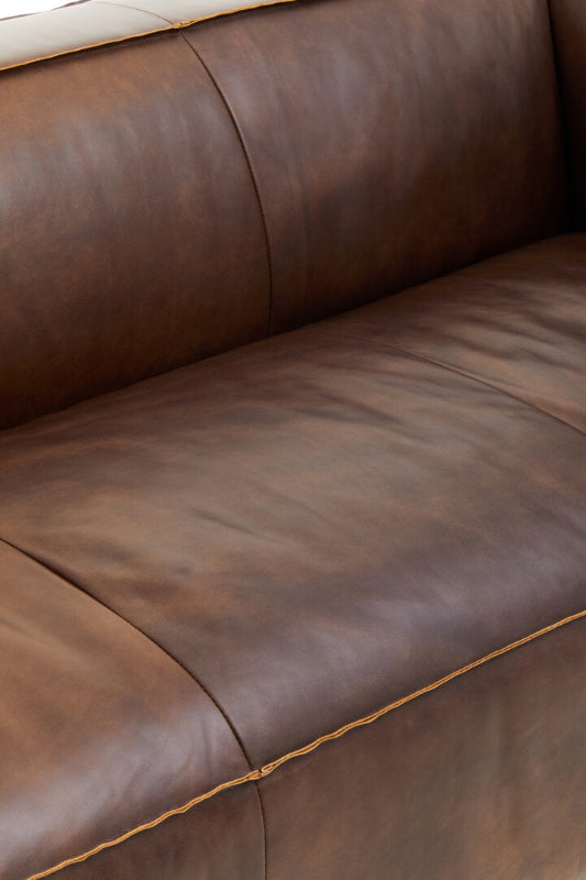 Close-up of a brown leather sofa.