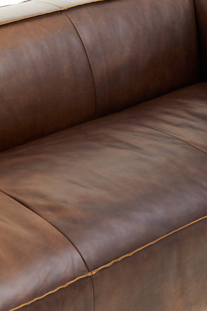 Close-up of a brown leather sofa.