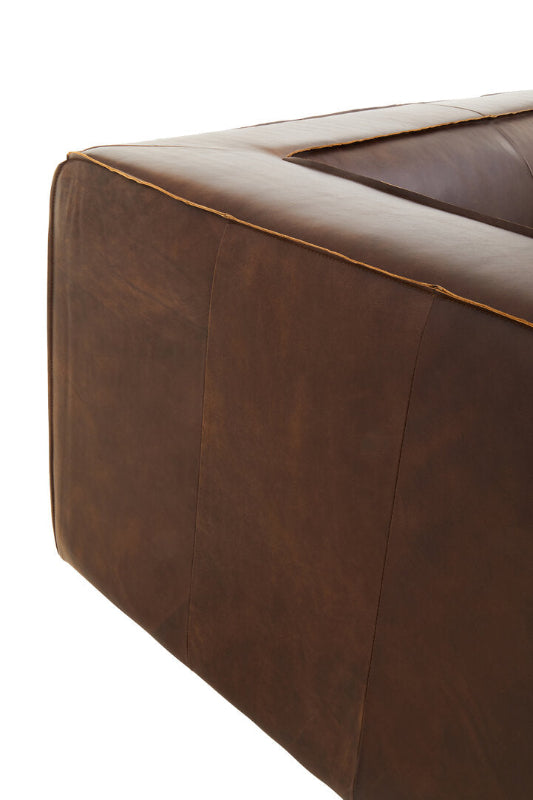 Close-up of a brown leather sofa corner on a white background