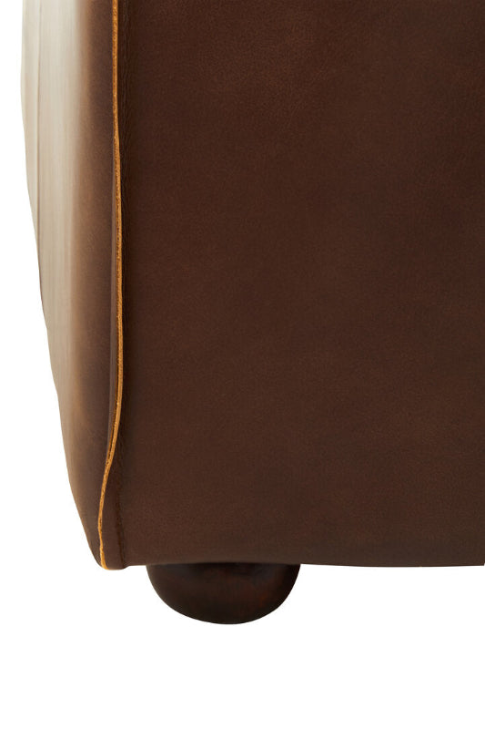 Close-up of a brown leather sofa corner on a white background