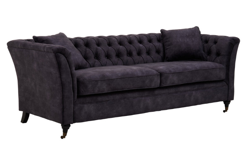 Dark grey tufted sofa on a white background