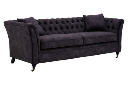Dark grey tufted sofa on a white background