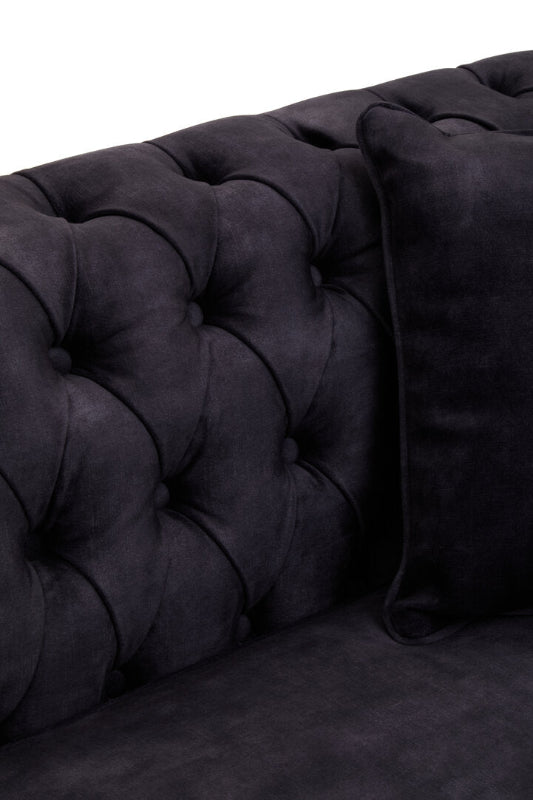 Dark gray tufted sofa with a pillow on a white background