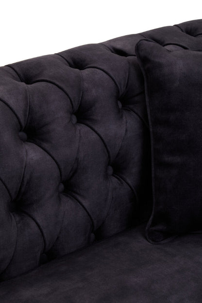 Dark gray tufted sofa with a pillow on a white background