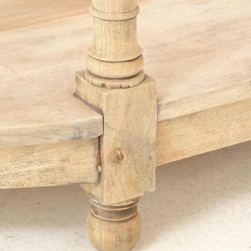 Close-up of a light natural wood table corner with a turned wooden leg and visible wood grain texture.