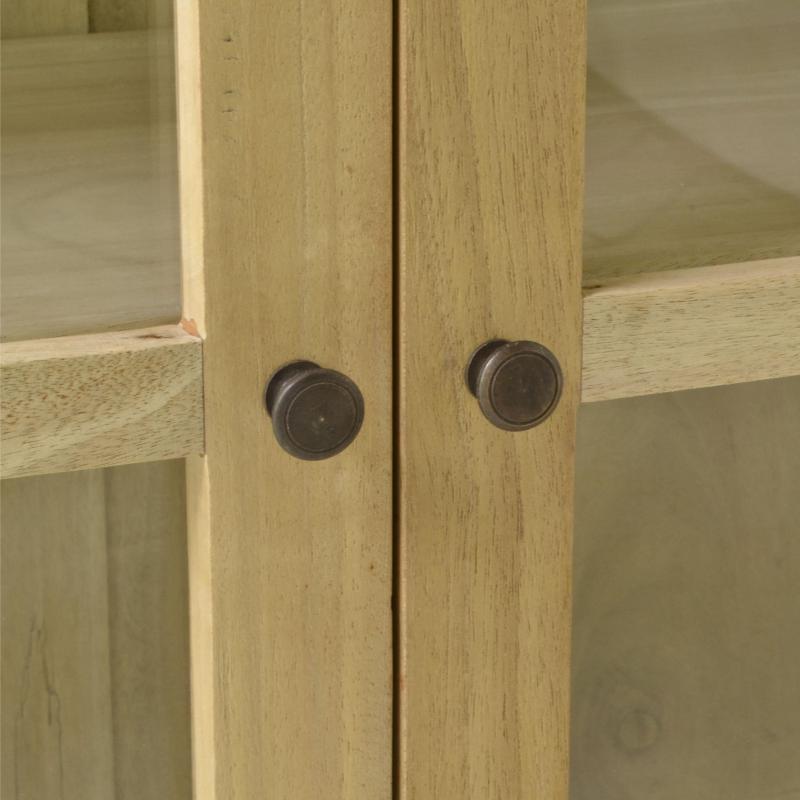 Close-up of a light natural wood cabinet door with two round dark metal knobs.