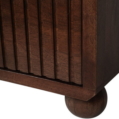 Close-up of a wooden cabinet corner with a round leg on a white background