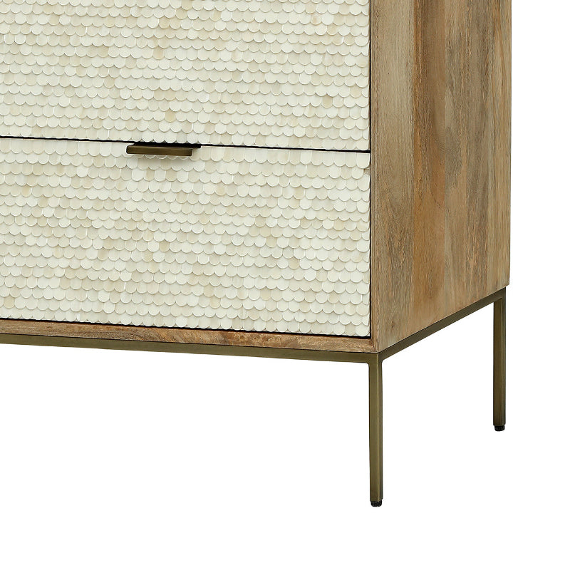 Wooden dresser with shell-patterned drawer front on a white background