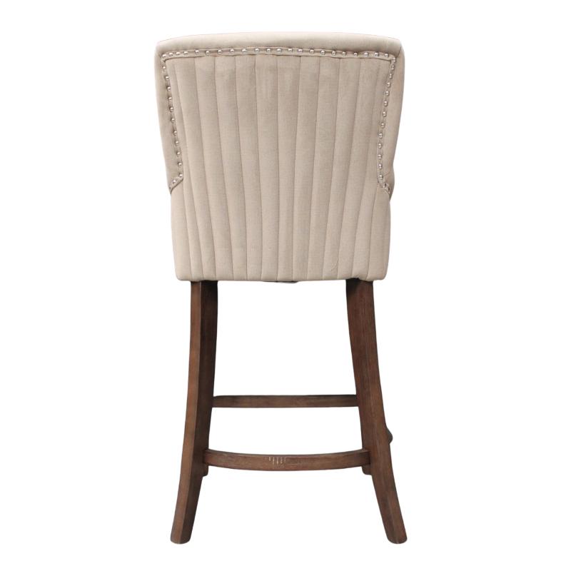 An upholstered bar stool with a cream-colored ribbed fabric seat and backrest, accented with nailhead trim, supported by a dark brown wooden frame with a footrest.