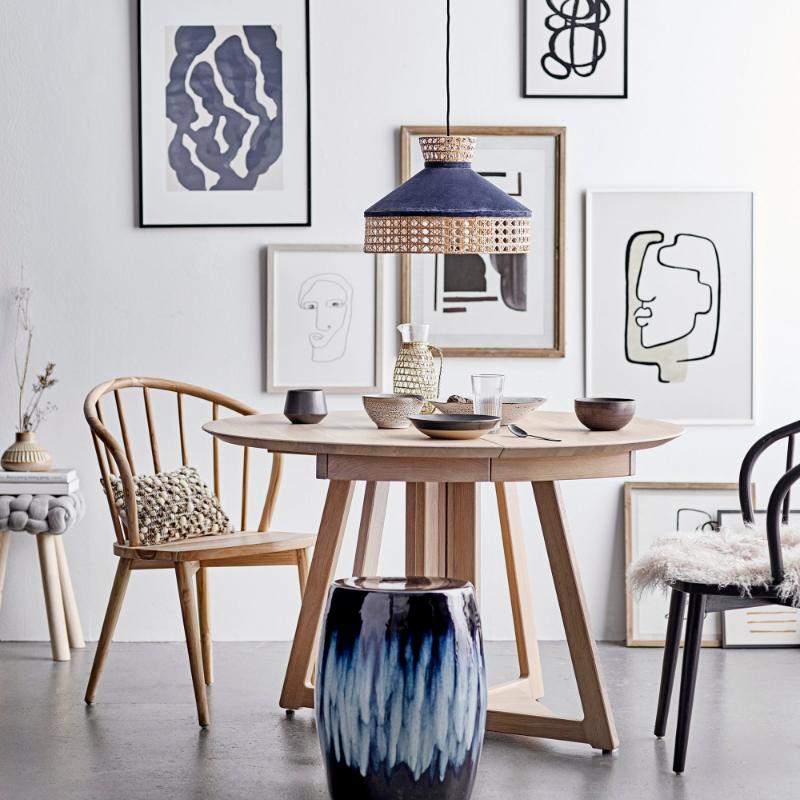 Modern dining room with wooden table, chairs, and abstract art on the wall.