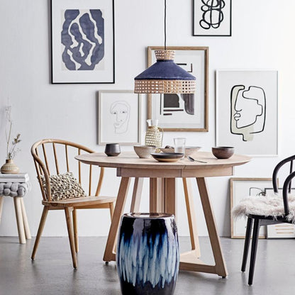 Modern dining room with wooden table, chairs, and abstract art on the wall.