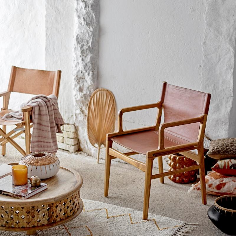 Modern living room with wooden chairs, a coffee table, and decorative items.