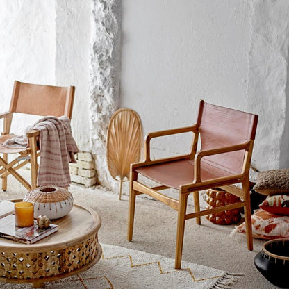 Modern living room with wooden chairs, a coffee table, and decorative items.
