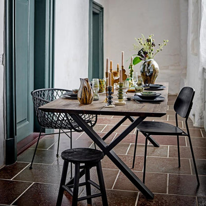 Dining area with a table set for a meal, featuring chairs and decorative items.
