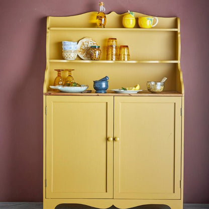 Yellow cabinet with decorative items against a purple wall