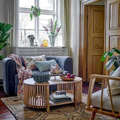 Living room with a blue sofa, wooden coffee table, and decorative items.