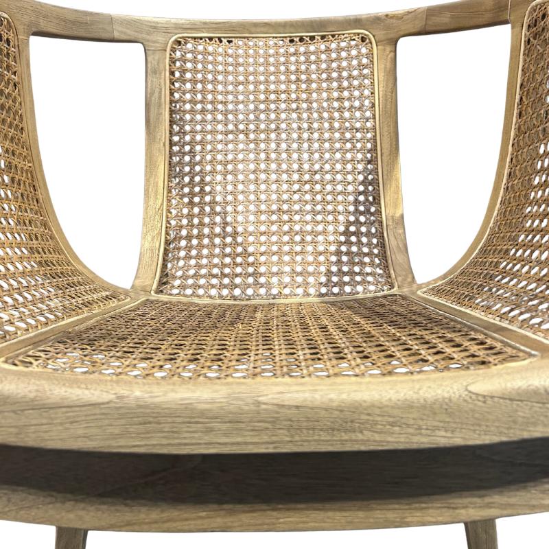 Close-up of a wooden chair with woven cane or rattan seat and back panels, showing the natural tan material and light wood frame against a white background.