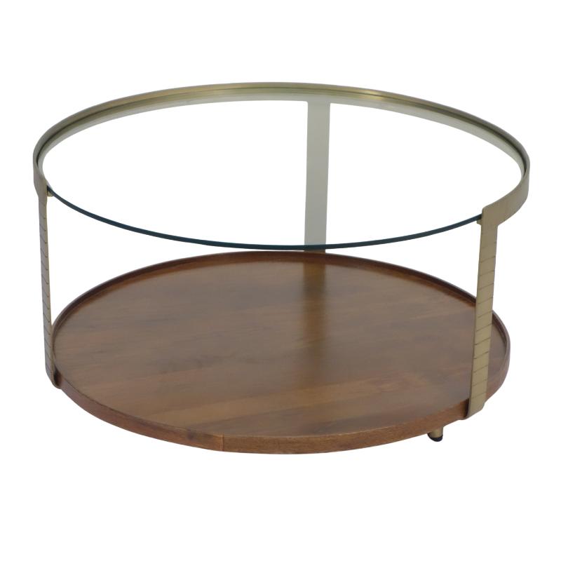 A round two-tier coffee table with a medium brown wooden bottom shelf, a clear glass top, and a brushed brass metal frame.
