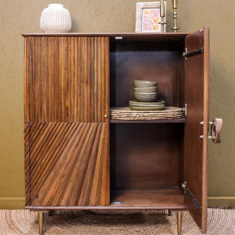 Wooden cabinet with open door displaying interior shelves against a beige wall.