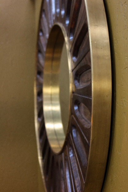 Close-up of a metallic gear or wheel on a brown background