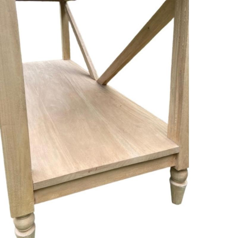 Close-up of a light natural wood furniture piece, showing the shelf, leg, and decorative turned feet against a plain white background.