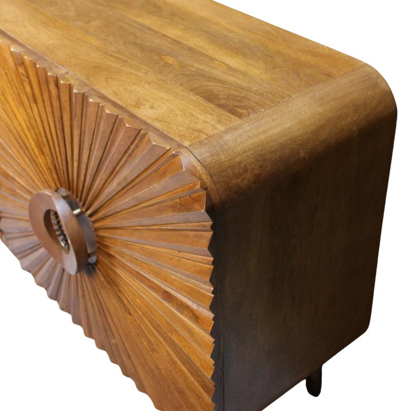 A close-up of a mid-century modern wooden cabinet featuring a curved top, dark brown side panels, and a sunburst fan-patterned drawer front with a round metal pull.