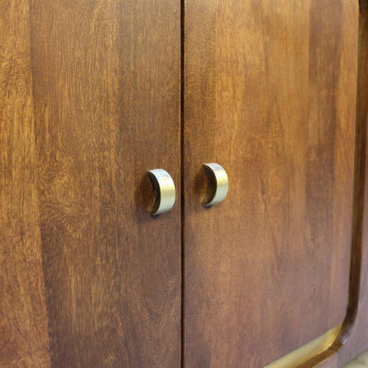 Close-up of a wooden cabinet door with two curved metallic handles, showing warm medium-brown wood grain and brushed silver hardware.