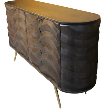 A mid-century modern wooden sideboard with a wavy, layered wood-grain cabinet door design, a smooth medium-brown wood top, and slim gold-toned metal legs, shown in an indoor setting.