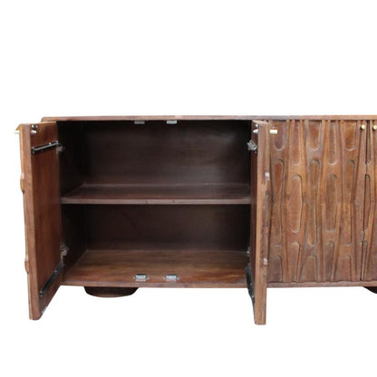A mid-century modern wooden sideboard cabinet with one door open, showing two interior shelves, and one side featuring vertically grooved patterned doors, set against a beige wall and concrete floor.