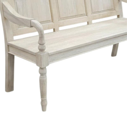 A rustic bleached wooden bench with a paneled backrest, curved armrest, and turned legs, shown against a plain white background.