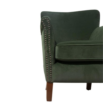 Dark green velvet armchair with silver nailhead trim and wooden legs, shown from a side angle on a white background.