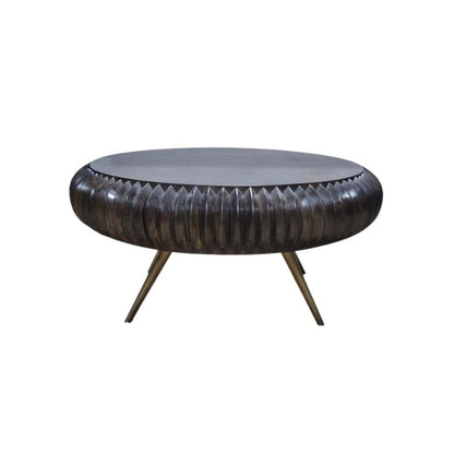 A round coffee table with a dark textured, ribbed metal body and three angled metal legs, shown against a plain white background.
