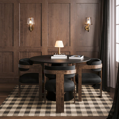 Dining room with wooden table and chairs on a checkered rug, against a wooden paneled wall.