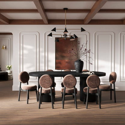 Dining room with a round black table and six chairs in a stylishly decorated room.