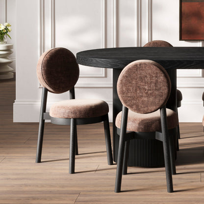 Dining table with round chairs in a room with wooden flooring and white walls.