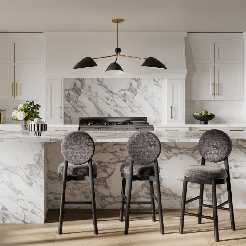 Modern kitchen with marble island, stools, and pendant light.