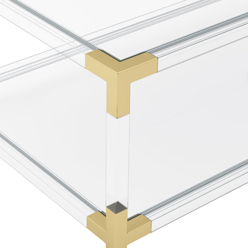 Clear Acrylic coffee table with gold metal legs on a white background