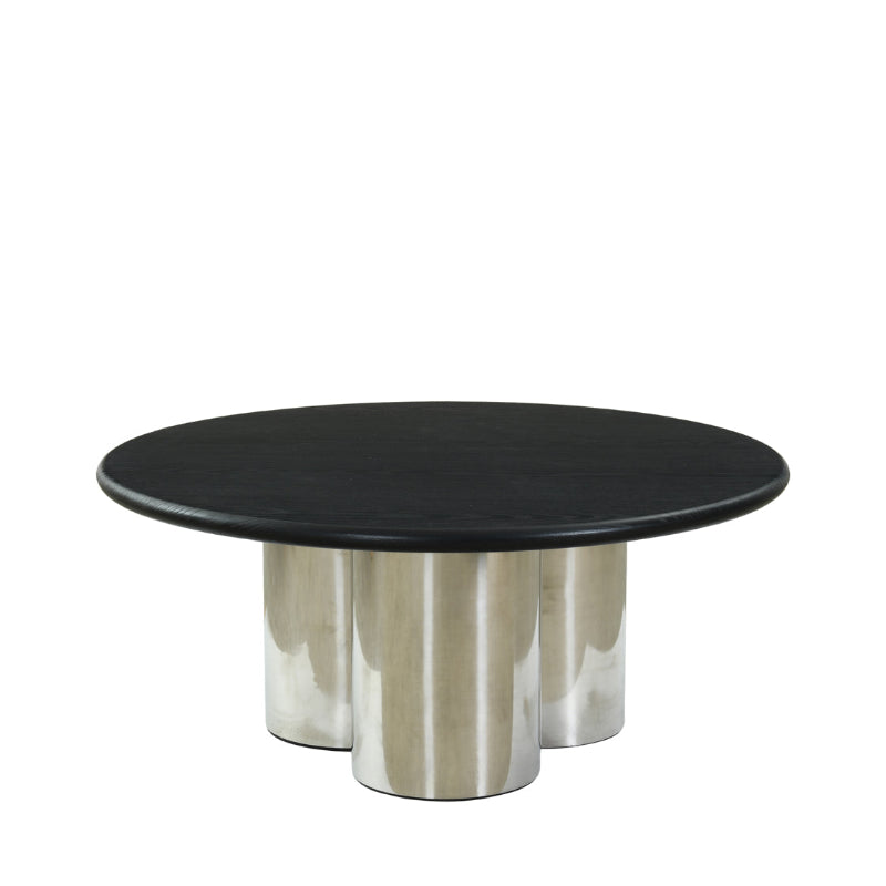 A modern round coffee table with a black wood top and three polished silver metal cylindrical legs, shown against a plain white background.