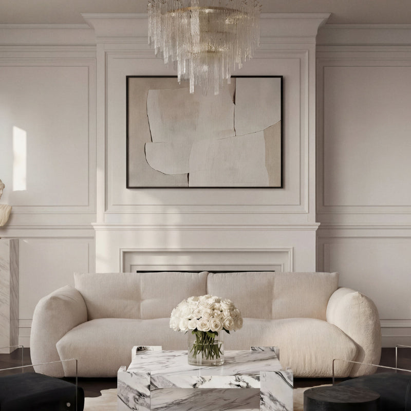 Modern living room with a white sofa, marble coffee table, and abstract art on the wall.