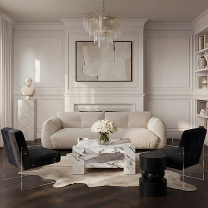 Modern living room with a beige sofa, black chairs, and a marble coffee table.