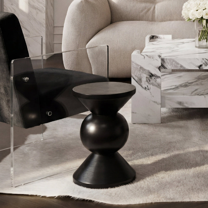 Modern living room with a black side table, clear chair, and marble coffee table.